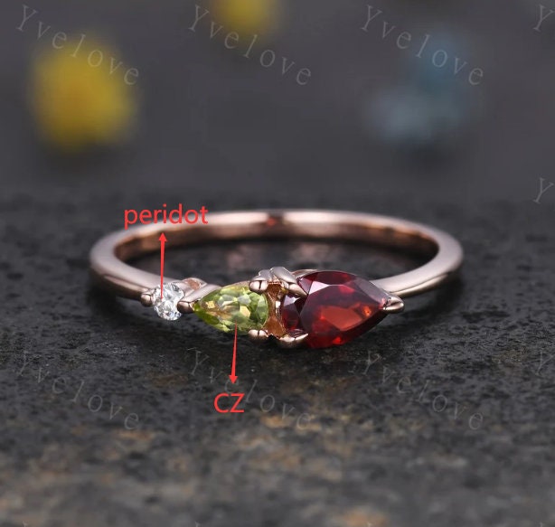 Custom for Gabrielle, 6x4mm pear garnet, 4x2.5mm pear CZ, 2mm round peridot, sterling silver. Engraving: D & E